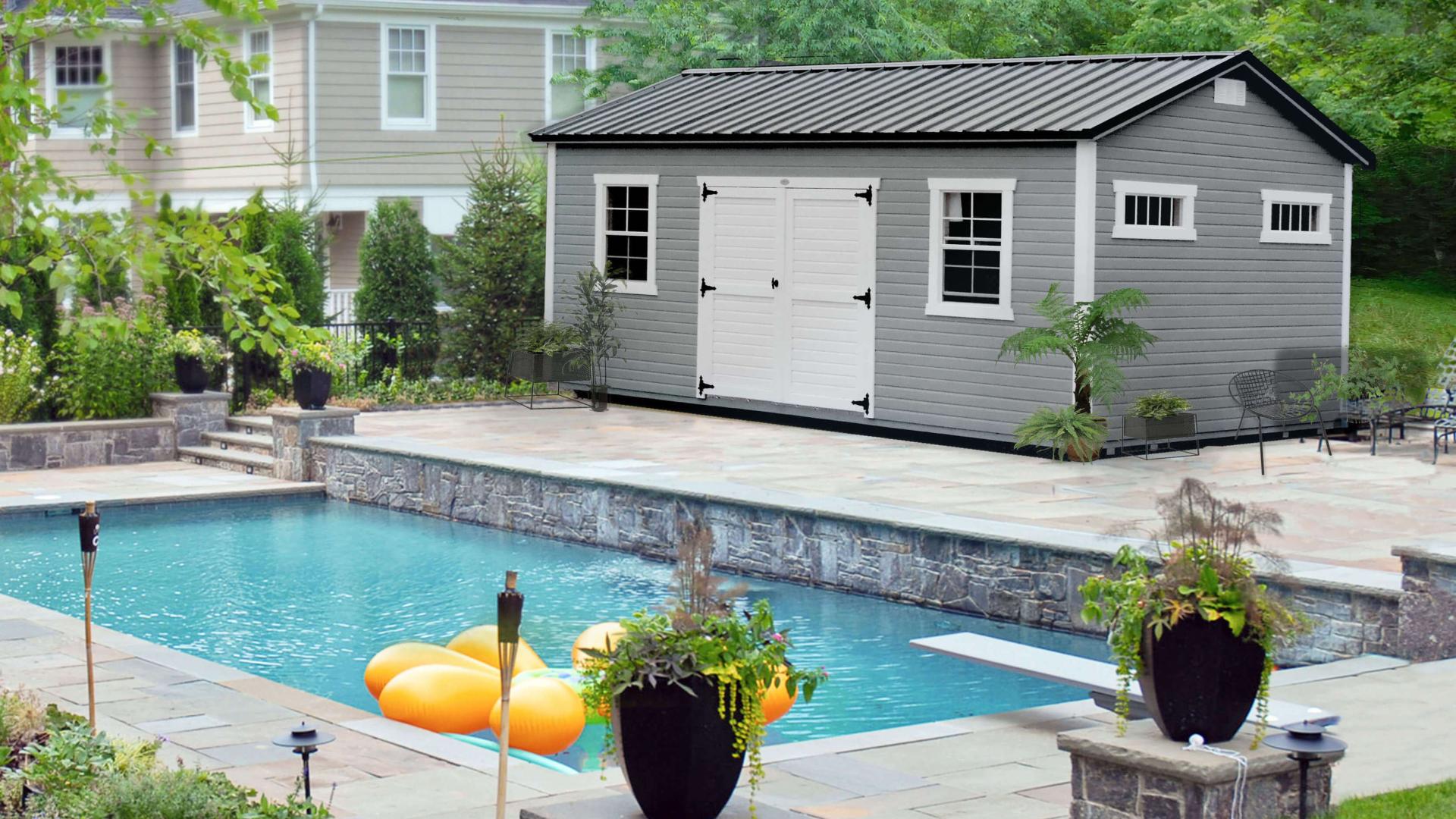 Gray storage shed with white trim by a pool